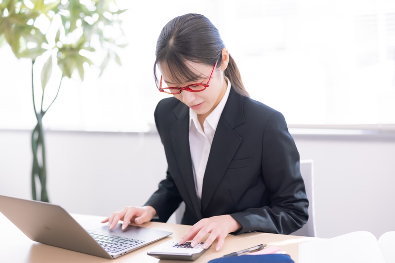 猫背の原因である不良姿勢でデスクワークをする女性のイメージ