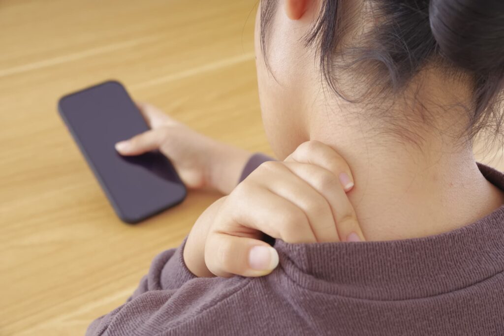 不良姿勢で頭痛が出ている女性のイメージ