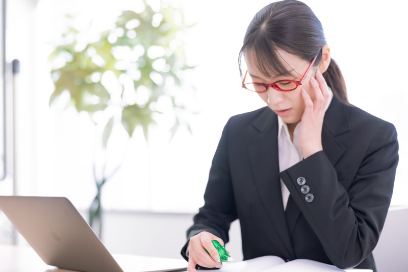 デスクワークでストレートネックになる女性のイメージ